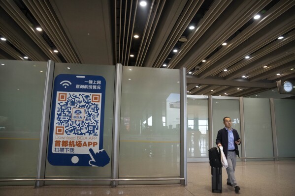 FILE - A traveler walks through the international flight arrivals area at Beijing Capital International Airport in Beijing, on April 26, 2023. China will no longer require a negative COVID-19 test result from incoming travelers starting Wednesday, Aug. 30, 2023. (AP Photo/Mark Schiefelbein, File)