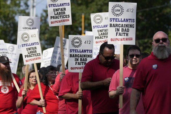 Trabajadores huelguistas del sindicato United Auto Workers marchan afuera de la sede de Stellantis en Norteamérica en Auburn Hills, Michigan, el miércoles 20 de septiembre de 2023. (AP Foto/Carlos Osorio)