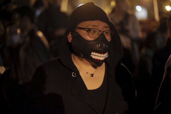 
              A Chinese immigrant wears a mask during a protest over the fatal shooting of a Chinese man in his apartment, in Paris, Tuesday, March 28, 2017. Chinese immigrants and China's government are protesting a police killing in Paris that prompted violent street clashes and exposed the fears and frustrations of France's large Asian community. (AP Photo/Thibault Camus)
            