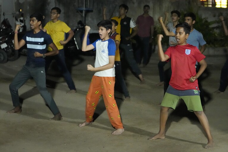 Youth and children participate in Hindu nationalist organisation Rashtriya Swayamsevak Sangh (RSS)'s shakha in Ahmedabad, India, April 8, 2024. Shakhas, or local units, induct boys by combining religious education with self-defense skills and games. (AP Photo/Ajit Solanki)