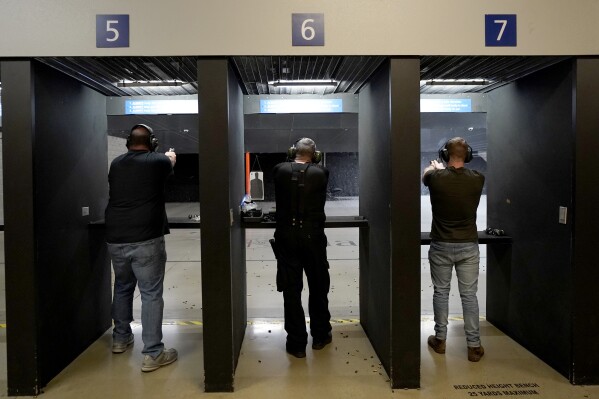 FILE - Gun owners fire their pistols at an indoor shooting range during a qualification course to renew their carry concealed handgun permits, July 1, 2022, at the Placer Sporting Club in Roseville, Calif. A California law that bans people from carrying firearms in most public places is taking effect on New Year's Day, even as a court case continues to challenge the law. (AP Photo/Rich Pedroncelli, File)