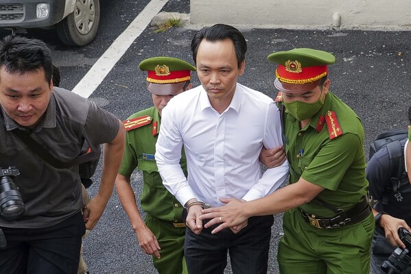 Trinh Van Quyet, a prominent Vietnamese business tycoon, is escorted to a court for his trial of defrauding stockholders, in Hanoi, Vietnam, July 22, 2024. (AP Photo/Anh Tuc)