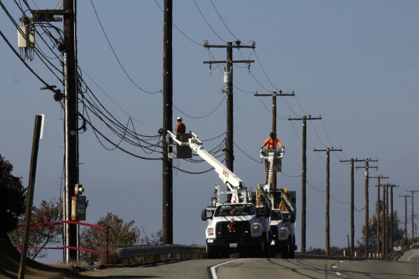 FILE -- Utility crews repair overhead lines along Pacific Coast Highway just west of Malibu, Calif., on Nov. 25, 2018. On Thursday, May 9, 2024, the California Public Utilities Commission will consider a change in how the state's investor-owned utilities calculate their customers' power bills. (AP Photo/John Antczak, File)