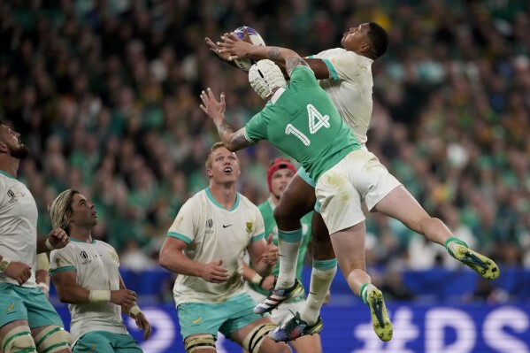 South Africa's Damian Willemse, right, and Ireland's Mack Hansen fight for the ball during the Rugby World Cup Pool B match between South Africa and Ireland at the Stade de France in Saint-Denis, outside Paris, Saturday, Sept. 23, 2023. (AP Photo/Christophe Ena)