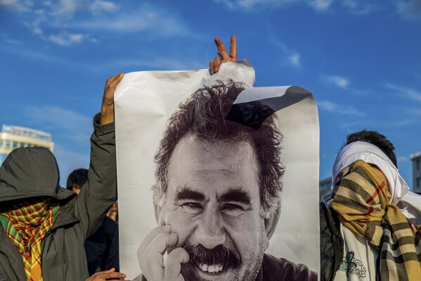 Youngsters hold a photograph of the jailed leader of the rebel Kurdistan Workers' Party, or PKK, Abdullah Ocalan as they gather to watch live on a tv screen a Pro-Kurdish Peoples' Equality and Democracy Party, or DEM, delegation members releasing an statement from Ocalan, in Diyarbakir, Turkey, Thursday, Feb. 27, 2025. (AP Photo/Metin Yoksu, File)