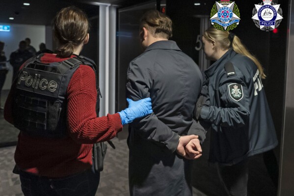 In this photo provided by the Australian Federal Police a man is taken into custody in Melbourne, Wednesday, June 14, 2023. A drug syndicate that tried to smuggle tons of methamphetamine from Canada to Australia and New Zealand by hiding it in shipments of maple syrup and canola oil has been busted, authorities said Thursday, June 15. (Australian Federal Police via AP)