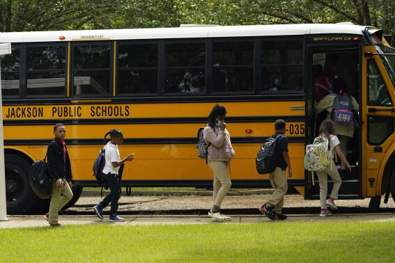 FILE - Spann Elementary School students board a school bus following a full day of in-school learning, Sept. 6, 2022, in Jackson, Miss. After the COVID-19 pandemic disrupted schools around the country and led to more children missing classes, the number of students who were chronically absent in Mississippi declined during the most recent school year, according to data released, Tuesday, Sept. 26, 2023, by the state's education department. (AP Photo/Rogelio V. Solis, File)