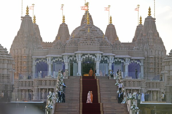 Indian Prime Minister Narendra Modi, left, walks across the carpeted steps with Hindu priest Brahmaviharidas Swami to inaugurate the first stone-built Hindu temple in the Middle East, belonging to Bochasanwasi Akshar Purushottam Swaminarayan Sanstha in Abu Mureikha, 40 kilometers (25 miles) northeast of Abu Dhabi, United Arab Emirates, Wednesday, Feb. 14, 2024. (AP Photo/Kamran Jebreili)