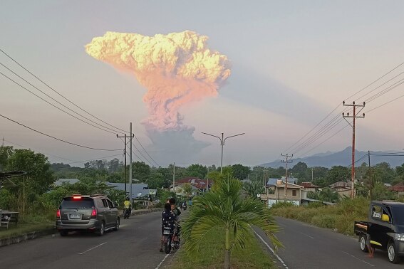 People watch as Mount Lewotobi Laki-Laki spews volcanic materials into the air during an eruption, in Maumere, Indonesia, Tuesday, June 17, 2025. (AP Photo)