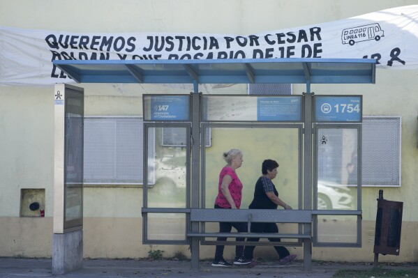 A banner hangs over a bus stop asking for justice regarding the murder of bus driver Cesar Roldan in Rosario, Argentina, Tuesday, April 9, 2024. (AP Photo/Natacha Pisarenko)