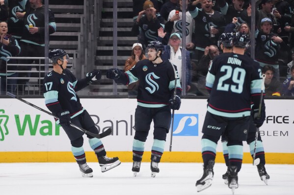 Seattle Kraken left wing Tye Kartye, second from left, celebrates his goal against the Vancouver Canucks with Jaden Schwartz (17) during the second period of an NHL hockey game Friday, Nov. 24, 2023, in Seattle. (AP Photo/Lindsey Wasson)