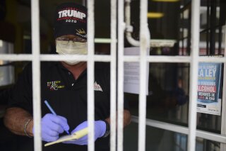 Jose Cepeda takes orders from customers at at Alto del Cabro restaurant amid a government ordered quarantine aimed at curbing the spread of the new coronavirus that is shuttering all non-essential businesses for two weeks in San Juan, Puerto Rico, Friday, March 20, 2020. (AP Photo/Carlos Giusti)