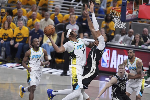 Indiana Pacers' Myles Turner (33) heads to the basket as Milwaukee Bucks' Giannis Antetokounmpo defends during the second half of a first-round NBA basketball playoff game, Saturday, April 19, 2025, in Indianapolis. (AP Photo/Michael Conroy)