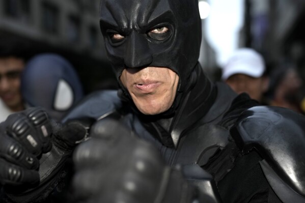 A supporter of presidential hopeful Javier Milei wears a Batman costume outside Milei's campaign headquarters after polls closed for general elections in Buenos Aires, Argentina, Sunday, Oct. 22, 2023. (AP Photo/Rodrigo Abd)