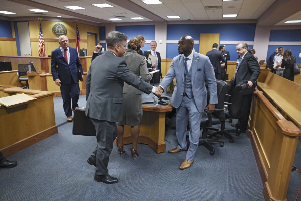 Attorney Brian Rafferty (left), who is defending Sidney Powell, and Special Prosecutor Nathan Wade shake hands after Fulton County Superior Judge Scott McAfee heard motions from attorneys representing Ken Chesebro and Sidney Powell in Atlanta on Wednesday, Sept. 6, 2023. (Jason Getz/Atlanta Journal-Constitution via AP, Pool)