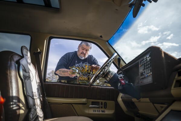 Lorenzo Otero polishes a car club emblem on his lowrider truck outside of the State Capitol in Santa Fe, N.M., on Lowrider Day, Tuesday, Feb. 11, 2025. (AP Photo/Roberto E. Rosales)