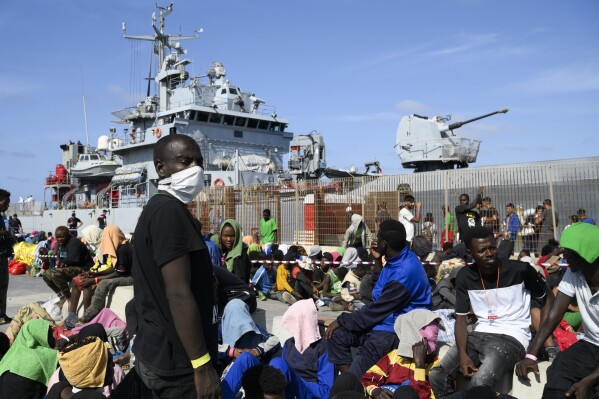 Migrants wait to be transferred from Lampedusa Island, Italy, Friday, Sept. 15, 2023. Thousands of migrants and refugees have landed on the Italian island of Lampedusa this week after crossing the Mediterranean Sea on small unseaworthy boats from Tunisia, overwhelming local authorities and aid organizations. (AP Photo/Valeria Ferraro)