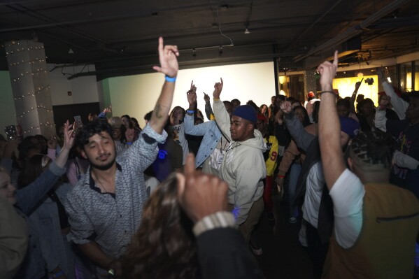 Attendees at The Cove, an 18-and-up, pop-up Christian nightclub, dance in unison on Saturday, Feb. 17, 2024, in Nashville, Tenn. More than 200 racially and ethnically diverse young clubbers attended The Cove's fourth event. (AP Photo/Jessie Wardarski)