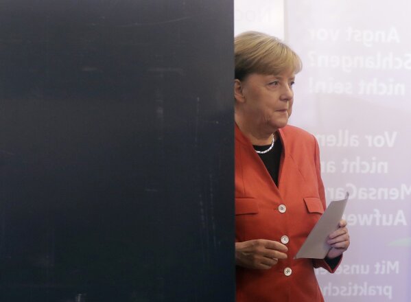 
              German Chancellor Angela Merkel leaves the election booth as she casts her vote in Berlin, Germany, Sunday, Sept. 24, 2017. Merkel is widely expected to win a fourth term in office as Germans go to the polls to elect a new parliament. (AP Photo/Markus Schreiber)
            