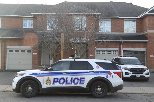 Police cars are parked at the scene where six people were found dead in the Barrhaven suburb of Ottawa on Thursday, March 7, 2024. (Patrick Doyle /The Canadian Press via AP)