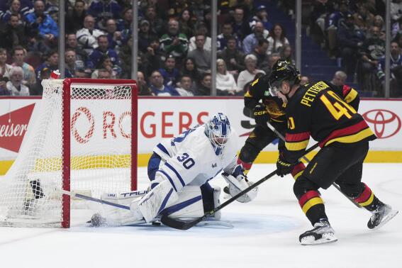 Vancouver Canucks' Elias Pettersson (40) scores a shorthanded goal against Toronto Maple Leafs goalie Matt Murray (30) during the third period of an NHL hockey game in Vancouver, British Columbia, on Saturday, March 4, 2023. (Darryl Dyck/The Canadian Press via AP)