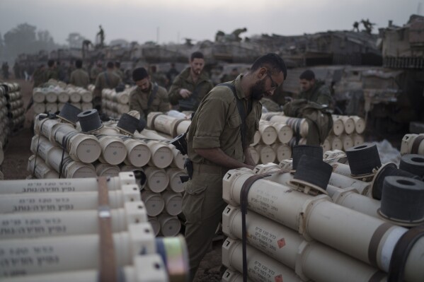 FILE - Israeli soldiers from the artillery unit store tank shells in a staging area at the Israeli-Gaza border in southern Israel, on Jan. 1, 2024. (AP Photo/Leo Correa, File)