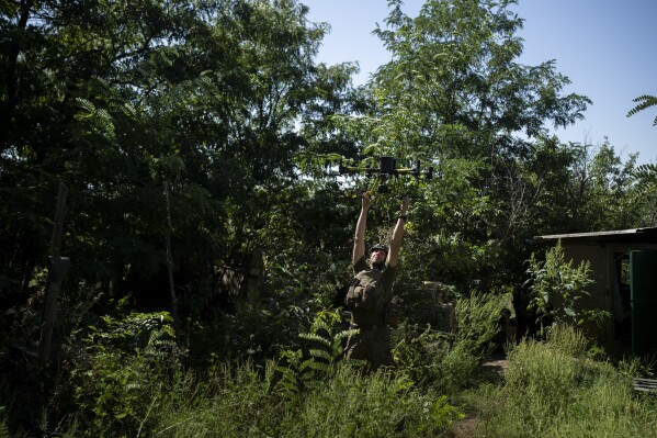 A Ukrainian solider grabs an intelligence drone during landing in the Luhansk region, Ukraine, Saturday, Aug. 19, 2023. Moscow’s army is staging a ferocious push in northeast Ukraine designed to distract Ukrainian forces from their counteroffensive and minimize the number of troops Kyiv is able to send to more important battles in the south. (AP Photo/Bram Janssen)