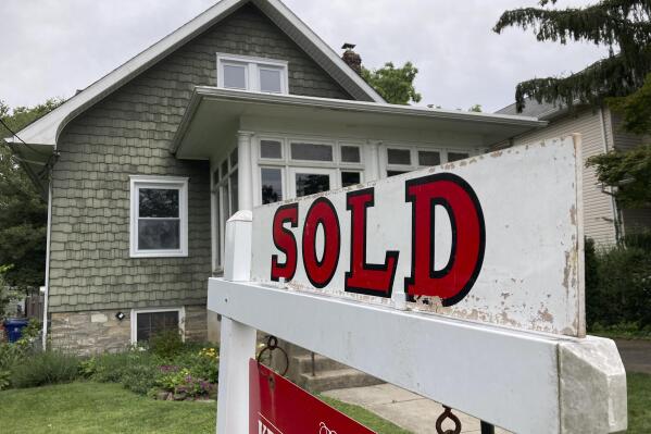 FILE - A "sold" is posted outside a single family home in a residential neighborhood, in Glenside, Pa., Wednesday, Aug. 4, 2021. Sales of previously occupied U.S. homes slowed for the fifth consecutive month in June 2022 as higher mortgage rates and rising prices kept many home hunters on the sidelines. The National Association of Realtors said Wednesday, July 20, that existing home sales fell 5.4% last month from May to a seasonally adjusted annual rate of 5.12 million. (AP Photo/Matt Rourke, File)