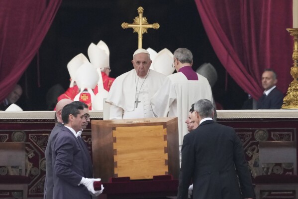Pope Francis, centre, sits as the coffin of late Pope Emeritus Benedict XVI St. Peter's Square is carrying during a funeral mass at the Vatican, Thursday, Jan. 5, 2023. (AP Photo/Alessandra Tarantino, file)
