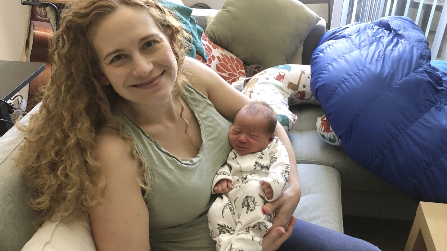 In this photo provided by Liz Chrastil, a neuroscientist with the University of California, Irvine, she her holds her newborn son in May 2020. (Courte