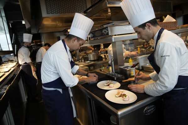 Des cuisiniers préparent à manger au restaurant La Tour d'Argent à Paris, le mercredi 13 décembre 2023. (AP Photo/Christophe Ena)