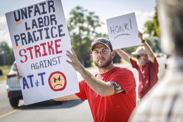 Drew Thigpen, left, and Robert Rogers join other AT&T workers from the CWA Local 3911 as they picket outside an AT&T warehouse on Cox Boulevard in Sheffield, Ala., on Monday, Aug. 19, 2024. (Dan Busey/The TimesDaily via AP)