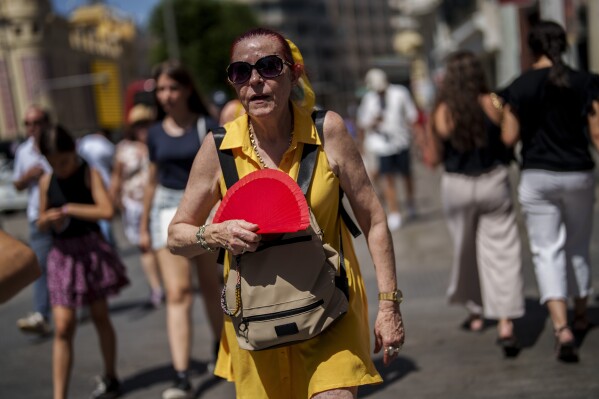 FILE - A woman fans herself in Madrid, Spain, July 10, 2023. Earth last year shattered global annual heat records, the European climate agency said Tuesday, Jan. 9, 2024. (AP Photo/Manu Fernandez, File)
