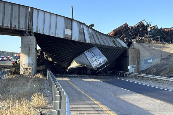 This image provided by the Colorado State Patrol shows a truck caught under a bridge that collapsed during a train derailment across a major highway near Pueblo, Colo., Sunday, Oct. 15, 2023. The main north-south highway in Colorado remained closed Monday morning and the Colorado Department of Transportation said it expected an 