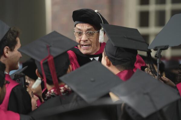 Actor Tom Hanks, center, greets graduating students during Harvard University commencement ceremonies, Thursday, May 25, 2023, on the school's campus, in Cambridge, Mass. (AP Photo/Steven Senne)