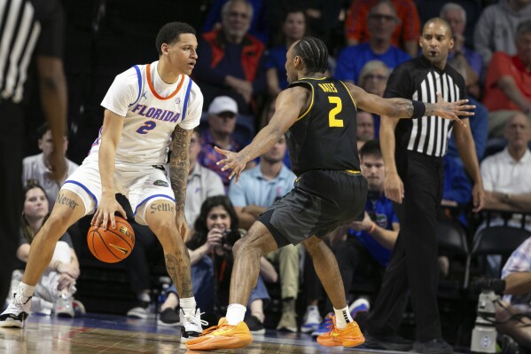 Florida guard Riley Kugel (2) gets pressure from Missouri guard Tamar Bates (2) during the first half of an NCAA college basketball game Wednesday, Feb. 28, 2024, in Gainesville, Fla. (AP Photo/Alan Youngblood)