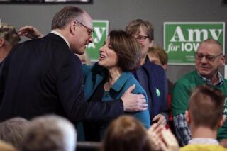FILE - In this Feb. 1, 2020 file photo Democratic presidential candidate Sen. Amy Klobuchar, D-Minn., center, gets a kiss from husband John Bessler, upon arriving at a rally in Sioux City, Iowa. Klobuchar's husband has been released from a hospital where he was being treated for low oxygen and pneumonia as a result of the Coronavirus, the senator said Thursday, March 26, 2020. (AP Photo/Gene J. Puskar File)