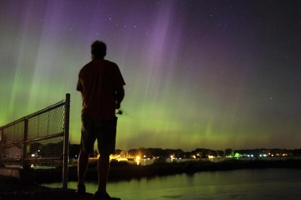 FILE - Wade Kitner looks at the northern lights as he fishes in Ventura, Iowa, on Tuesday, June 23, 2015.  A fireworks show that has nothing to do with the Fourth of July and everything to do with the cosmos is poised to be visible across the northern United States and Europe just in time for the Halloween weekend, Saturday, Oct. 30, 2021. (Arian Schuessler, The Globe Gazette via AP, File)