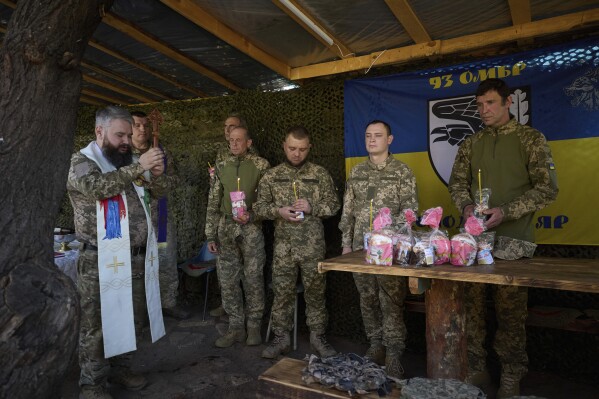 In this photo provided by Ukraine's 93rd Kholodnyi Yar Separate Mechanized Brigade press service, Ukrainian servicemen attend an Easter service on their position in the Donetsk region, Ukraine, Sunday, April 20, 2025. (Mykola Oliinyk/Ukraine's 93rd Mechanized Brigade via AP)