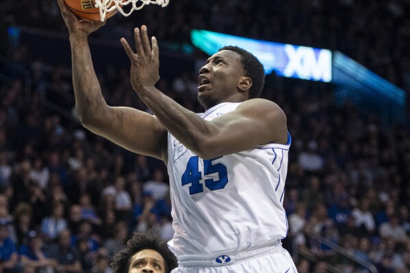 BYU forward Fousseyni Traore (45) lays the ball up past Kansas State forward Will McNair Jr., left, and guard Dorian Finister during the second half of an NCAA college basketball game Saturday, Feb. 10, 2024, in Provo, Utah. (AP Photo/Isaac Hale)