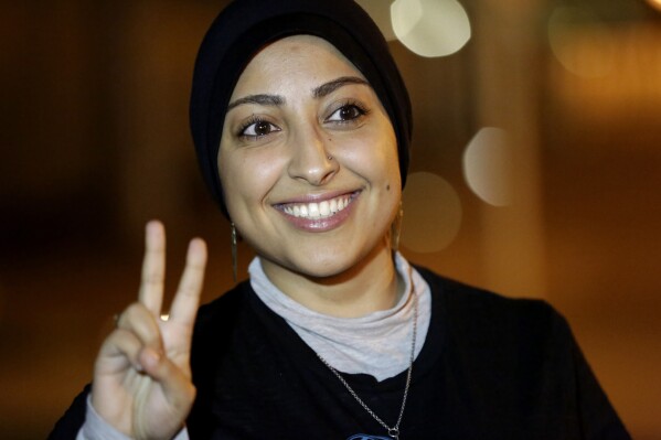 FILE - Human rights activist Maryam al-Khawaja flashes the victory sign outside a police station in Muharraq, Bahrain, on Sept. 18, 2014. Al-Khawaja, a daughter of a long-detained human rights activist in Bahrain, said Thursday, Sept. 7, 2023, that she would return to the island nation to press for his release amid a major hunger strike by him and hundreds of other inmates there, even though she could be imprisoned as well. (AP Photo/Hasan Jamali, File)