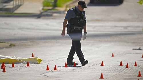 Evidence markers filled the street as police were investigating the scene after several people died and others were injured following a shooting early Sunday, June 25, 2023, near 57th Street and Prospect Avenue in Kansas City, Mo. (Tammy Ljungblad/The Kansas City Star via AP)