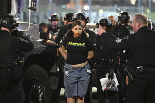 Law enforcement handcuff a woman during a protest on Thursday, June 12, 2025, in Los Angeles. (AP Photo/Wally Skalij)