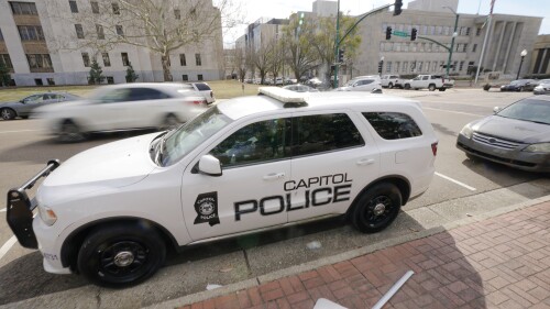 FILE - A Capitol Police SUV is parked across the street from the Hinds County Courthouse, left, and the main offices of the Jackson Police Department, right, in downtown Jackson, Miss., Feb. 13, 2023. On Wednesday, July 12, a federal judge dismissed a lawsuit filed by Latasha Smith, a Mississippi woman who says she was hit by a stray police bullet while lying in bed. Smith was in bed when an officer from the state-run Capitol Police fired several bullets at a suspect running through her Jackson apartment complex, according to her federal complaint. (AP Photo/Rogelio V. Solis, File)