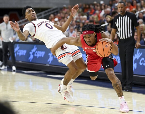 Georgia guard Silas Demary (5) drives past Auburn guard Tahaad Pettiford (0) during the first half an NCAA college basketball game Saturday, Feb. 22, 2025, in Auburn, Ala. (AP Photo/Julie Bennett)