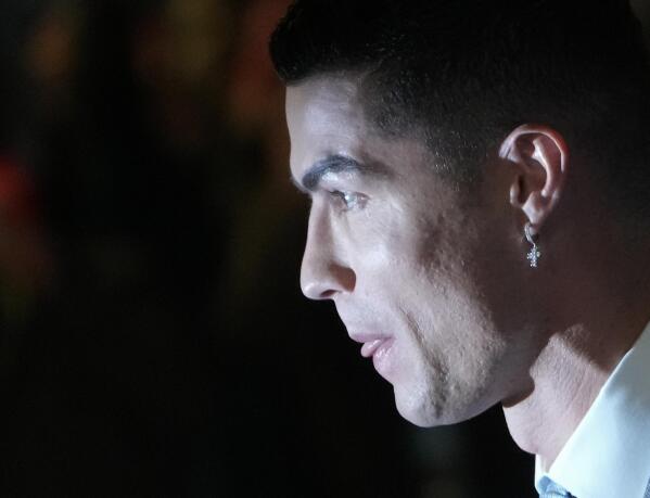 Cristiano Ronaldo wears an earring with a cross as he attends the official unveiling as a new member of Al Nassr soccer club in in Riyadh, Saudi Arabia, Tuesday, Jan. 3, 2023. Ronaldo, who has won five Ballon d'Ors awards for the best soccer player in the world and five Champions League titles, will play outside of Europe for the first time in his storied career. (AP Photo/Amr Nabil)