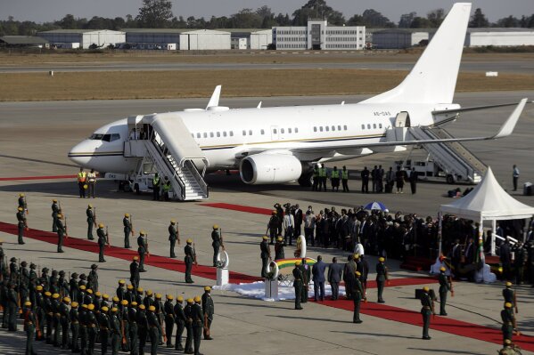 FILE - In this Sept. 11, 2019, file photo, a coffin carrying the body of Zimbabwe's former ruler Robert Mugabe arrives from Singapore, at the airport in Harare, Zimbabwe. The coronavirus pandemic could narrow one gaping inequality in Africa, where some heads of state and other elite jet off to Europe or Asia for health care unavailable in their nations but as global travel restrictions tighten, they might have to take their chances at home. (AP Photo/Themba Hadebe, File)