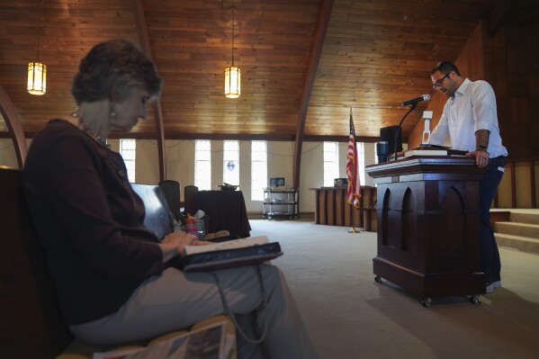 Pastor Ryan Burge, right, an associate professor of political science at Eastern Illinois University and author of "The Nones," a book on the growing number of religiously unaffiliated Americans, preaches a sermon at First Baptist Church in Mt. Vernon, Ill., Sunday, Sept. 10, 2023.  (AP Photo/Jessie Wardarski)