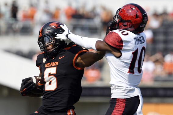 Oregon State running back Damien Martinez (6) fights off a tackle from San Diego State cornerback Noah Tumblin (10) during the first half of an NCAA college football game Saturday, Sept. 16, 2023, in Corvallis, Ore. (AP Photo/Mark Ylen)