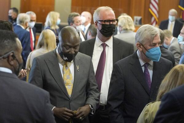 Attorneys Ben Crump, left, representing the father of victim, Ezra Blount, left, Neal Manne, representing Live Nation, right, and others are shown leaving from a status conference about Astroworld litigation before Judge Kristen Hawkins Tuesday, March 1, 2022, in Houston. ( Melissa Phillip/Houston Chronicle via AP)